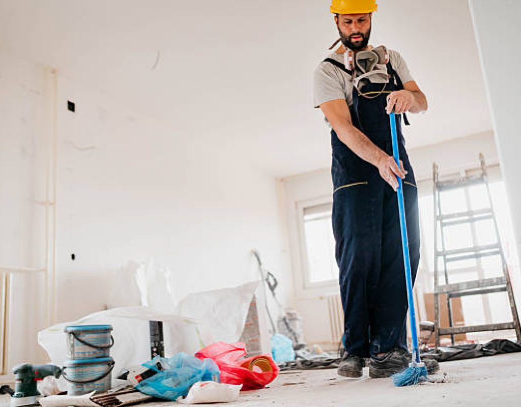 Worker vacuuming fine dust after renovation in residential property