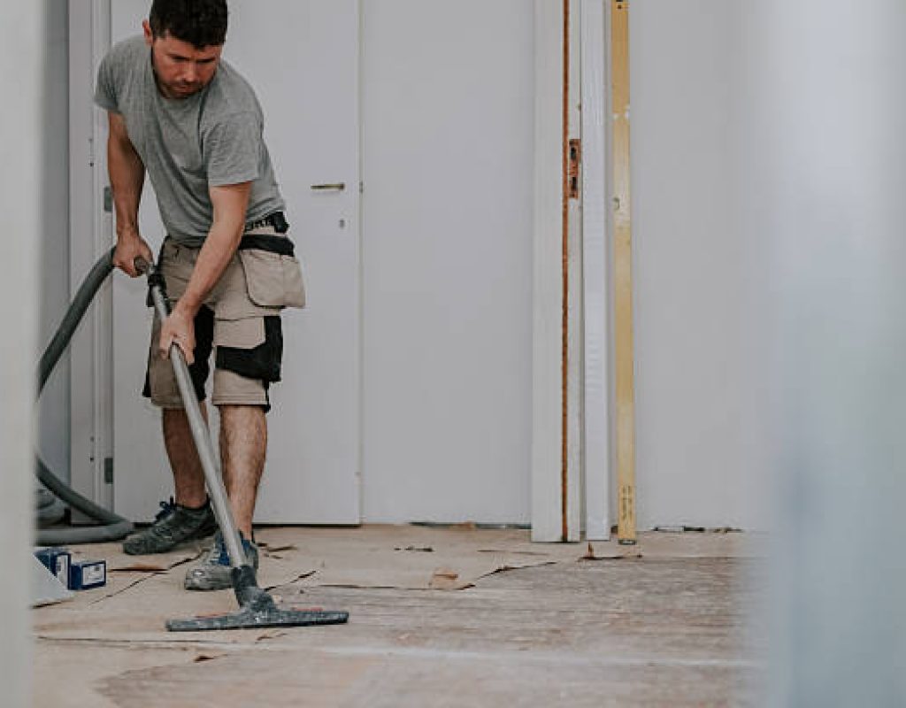 Post construction cleaning team removing dust and debris from new build interior